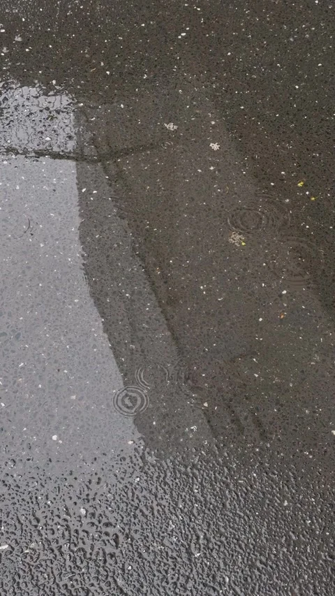 Raindrop liquid falling onto dark wet textured asphalt surface, creating Stock Footage 333163812