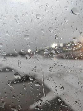Raindrops on airplane window with wing in background Stock Photos