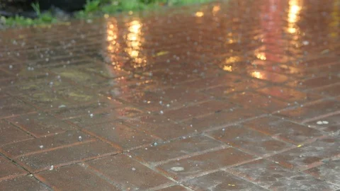 Raindrops and hail fall on the paved sidewalk	 Видео 105344878