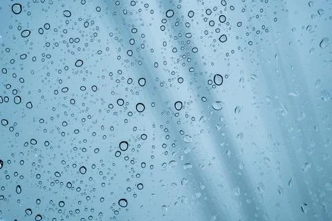 Raindrops and water droplets on window glass surface background. Stock Photos