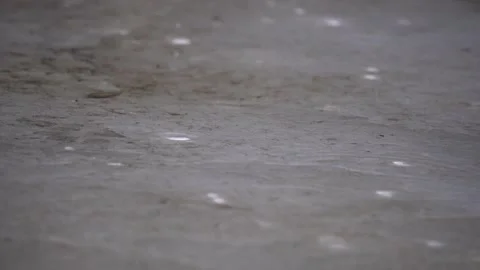 Raindrops are falling on a puddle on a gray concrete Stock Footage 175635985