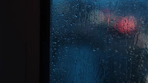 Raindrops background of a blurred night city with cars. Stockbeeldmateriaal 270580870