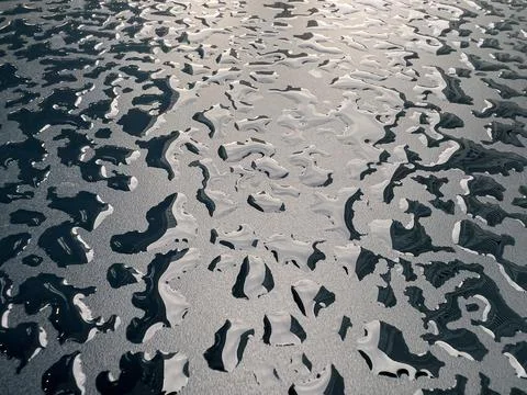 Raindrops on the black table surface that forms some abstract conceptual back Stock Photos