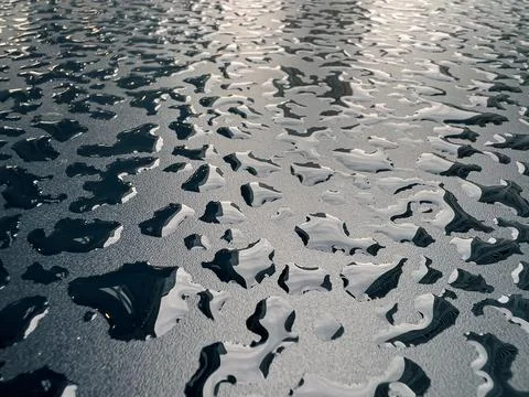 Raindrops on the black table surface that forms some abstract conceptual back Foto stock