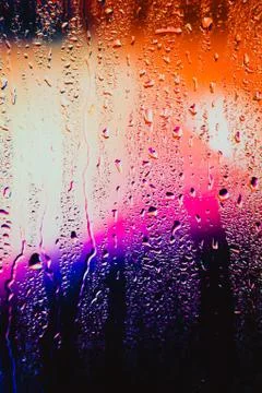 Raindrops on a blurred multicolored background Stock Photos