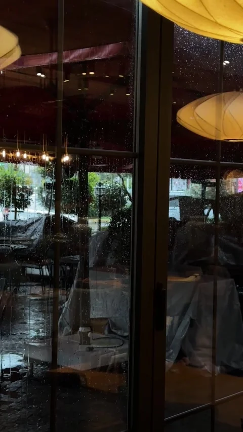 Raindrops on Café Window with Interior Reflections Stock Footage 305659333