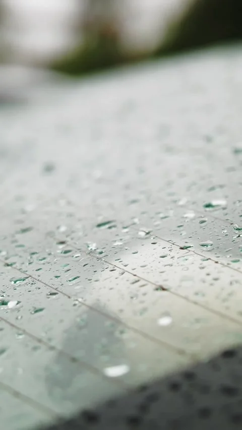 Raindrops on car. rain. raining. raindrops fall to rear windshield of white car Stock Footage 310950649