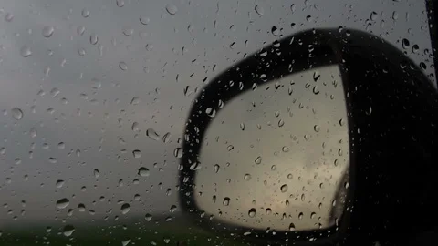 Raindrops on car window against wing mirror Stock Footage 95077770