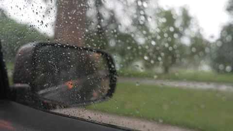 Raindrops on car window and side mirror during a rainy drive Stock Footage 340833750
