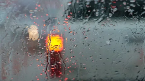 Raindrops on Car Window with Blurred Traffic Light Stock Footage 327107336