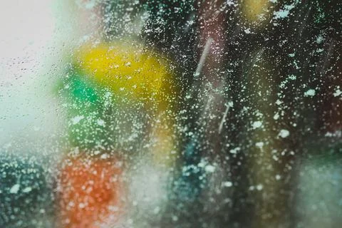 Raindrops on car window with blurred traffic lights Stock Photos