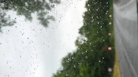 Raindrops on car window focusing side mirror, stormy atmosphere outside, concept Stock Footage 313613420