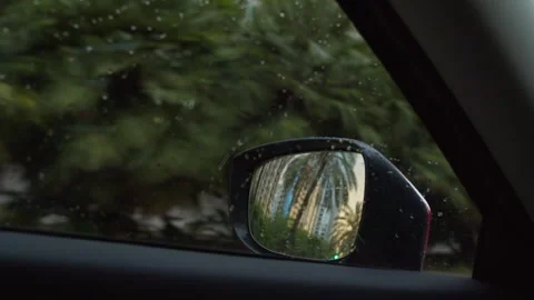 Raindrops on car window with side mirror view Stock Footage 263133244