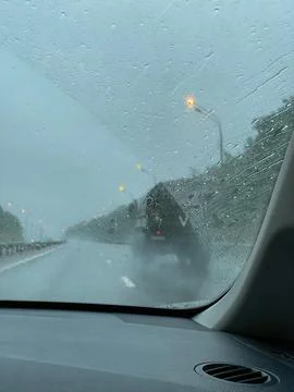 Raindrops on the car window. View on the traffic during the rain in the evening Stock Photos
