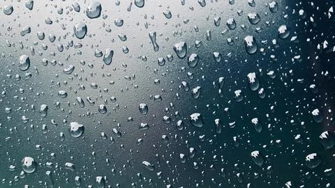 Raindrops on a car windshield, blurring the view of the road ahead Foto stock