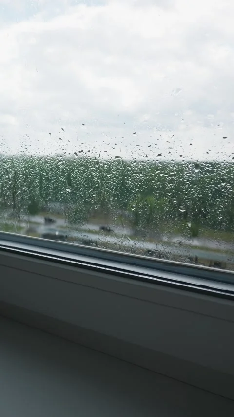 Raindrops Clinging to Window Pane in High Rise Apartment Close-Up Stock Footage 345426632