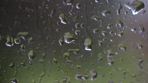 Raindrops clinging to window pane surface, water droplets slowly sliding down Stock Footage 329621149