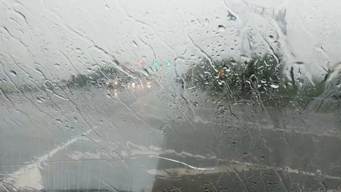 Raindrops close-up drops falling on the glass of the car. Road view from car Stock Footage 111949319