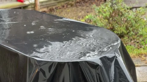 Raindrops on covered up garden table Stock Footage 296372122