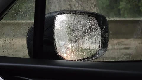 Raindrops covering car side mirror during heavy rain Vidéo 315360329