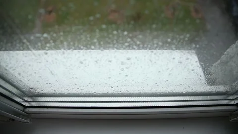 Raindrops covering glass surface of window during heavy downpour on gloomy day 스톡 동영상 329212768