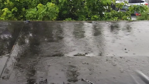 Raindrops create mesmerizing patterns on a dark roof Stock-Footage 315215046
