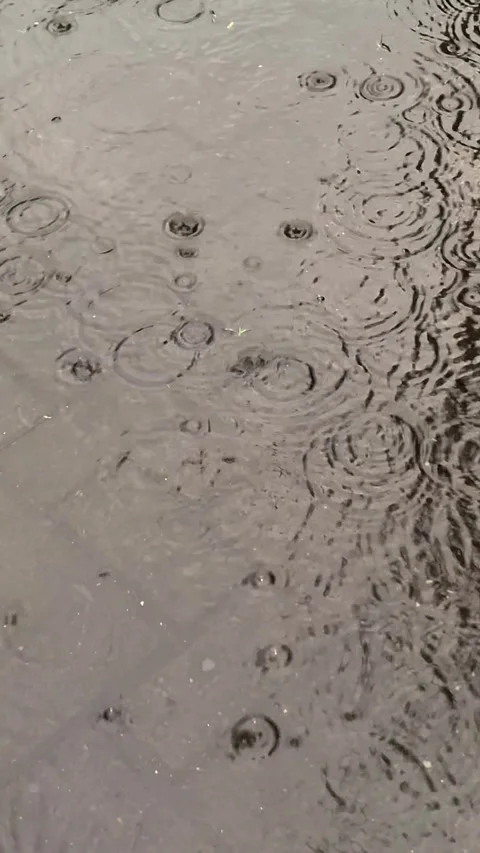 Raindrops create small ripples and circular water pattern on paved surfaces Stock Footage 296717838