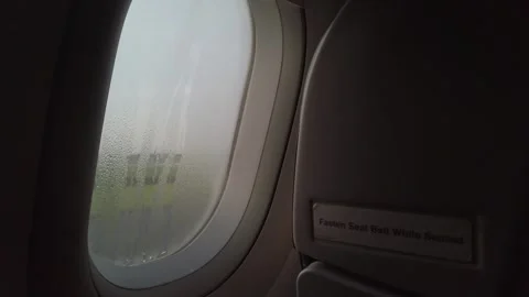 Raindrops dew on planewindow surface, A dewey morning sunrise as seen throu.. Видео 337929504