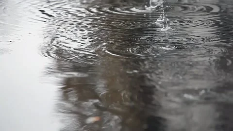 Raindrops drip from the roof into a puddle. The concept of autumn, rain Stock Footage 153380283