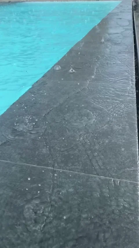 Raindrops drip into the water of the outdoor pool Stock Footage 284360067