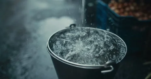 Raindrops Dripping into Bucket  Stockbeeldmateriaal 304316879