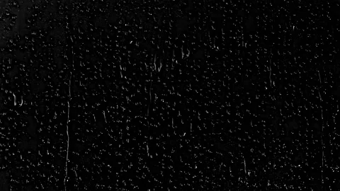 Raindrops dripping down window glass on black background Stock Footage 328644889