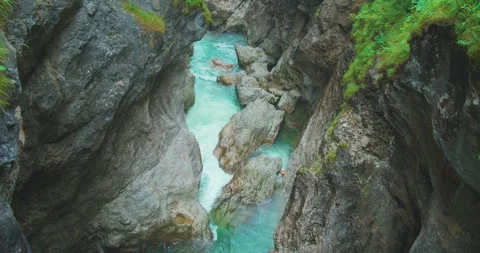 Raindrops dripping into a mountain river flowing in a canyon. Rocky gorge with Stock Footage 252837970