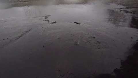 Raindrops dripping in slow motion onto the road with puddles. Stock Footage 165656975