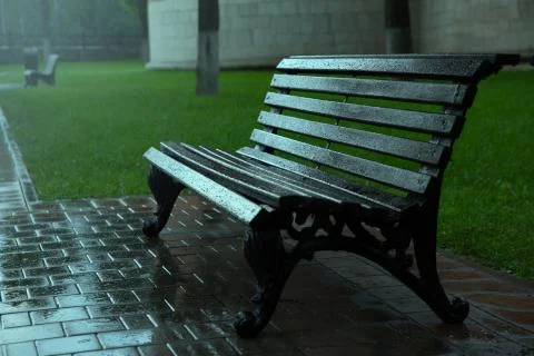 Raindrops on an empty park bench Stock Photos