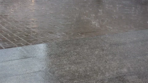 Raindrops on an empty pavement tile Stock Footage 139341251
