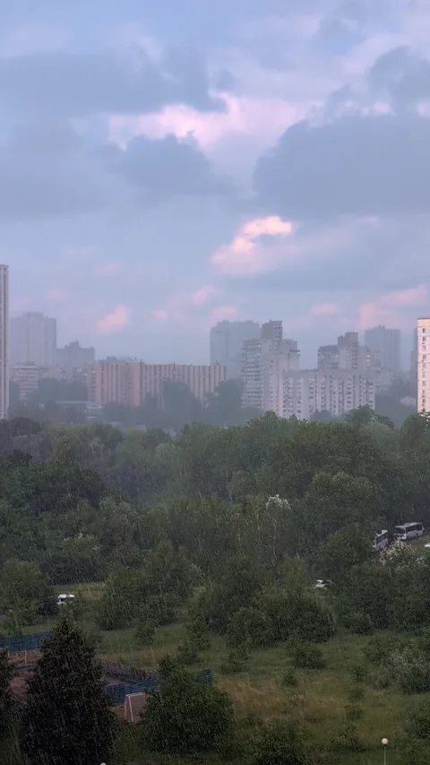 Raindrops fall against a backdrop of city houses on a sunny summer day. Ver.. Stock Footage 286805087