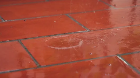 Raindrops fall and break on the balcony floor. The rainy season has begun. Stock Footage 328160647