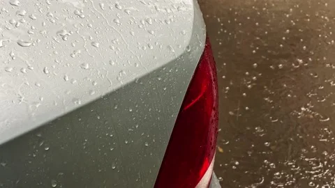 Raindrops fall and run down the silvery car outside view Stock Footage 208177289