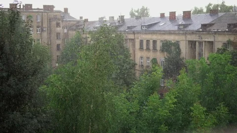 Raindrops fall on the background of the building and its roof and trees. Drops Stock Footage 92384324