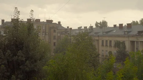 Raindrops fall on the background of the building and its roof and trees. Drops Stock Footage 92388197