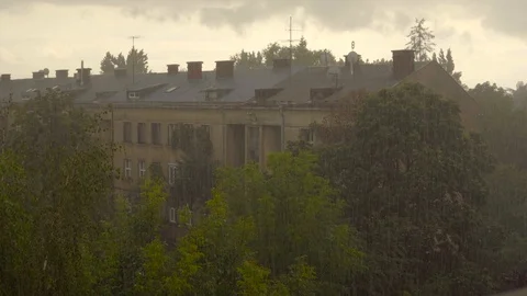 Raindrops fall on the background of the building and its roof and trees. Drops Video stock 92390274