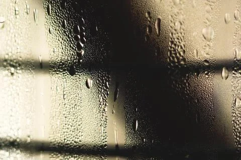 Raindrops fall down on the window in the rainy day.Close up. Stock Photos
