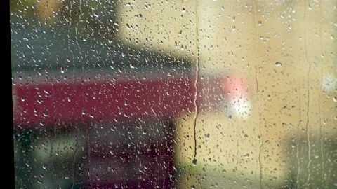 Raindrops fall down a window on a sunny day. Stock Footage
