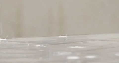 Raindrops Fall To The Ground In Slow Motion Over A Blurred Warm Background Stock Footage 136563364