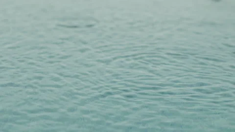 Raindrops fall into the pool, strong ripples, raindrops close-up in slow motion Stock Footage 166348813