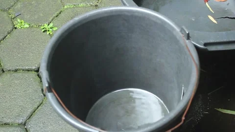 Raindrops fall into a rainwater collection bucket Stock Footage 274938449