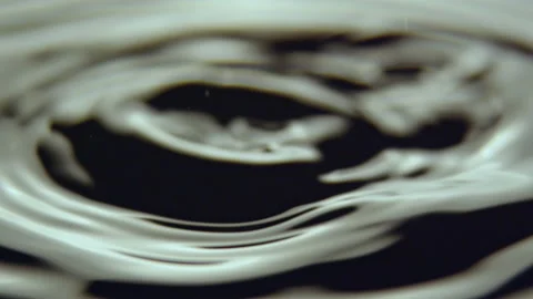 Raindrops fall on water making small oscillations and waves Stock Footage 234318286