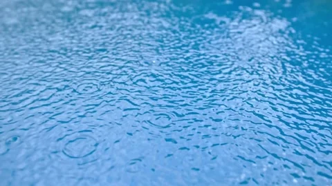 Raindrops fall on a water surface and create circles. Slow motion Stock Footage 167260300