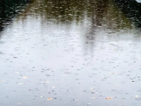 Raindrops fall on wet surface of asphalt road Stock Photos